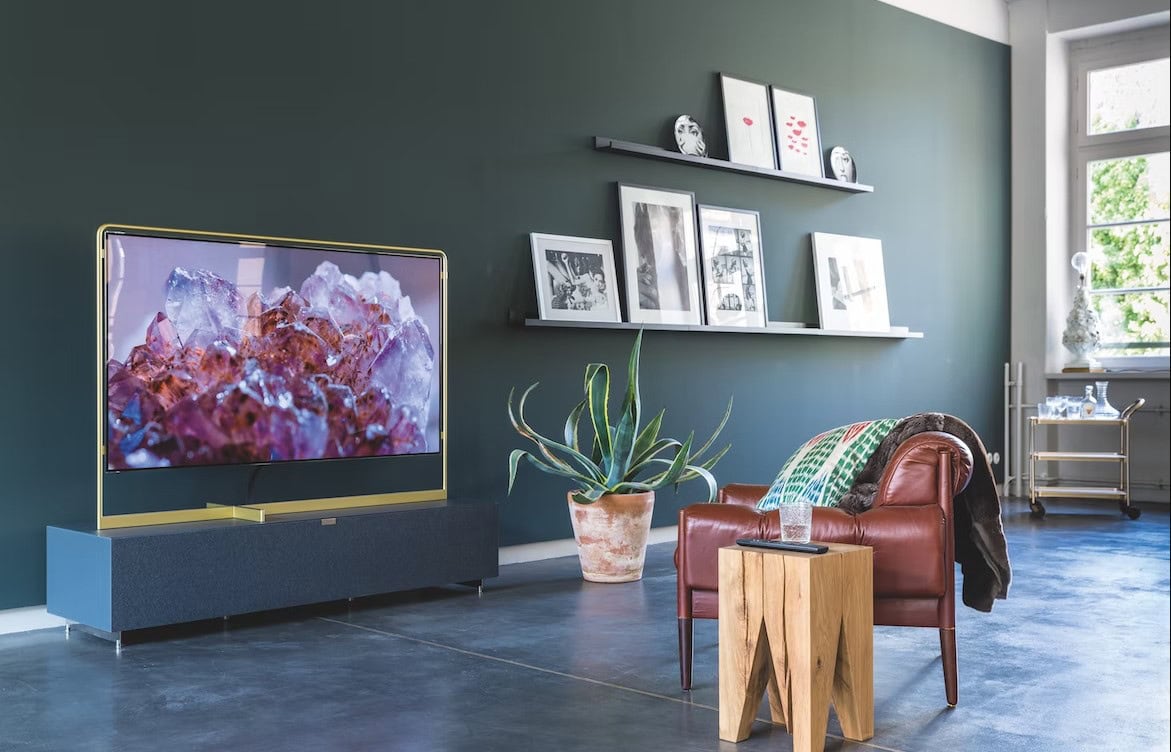 A sleek smart TV displays pink quartz crystals in a comfortable living room filled with natural light.